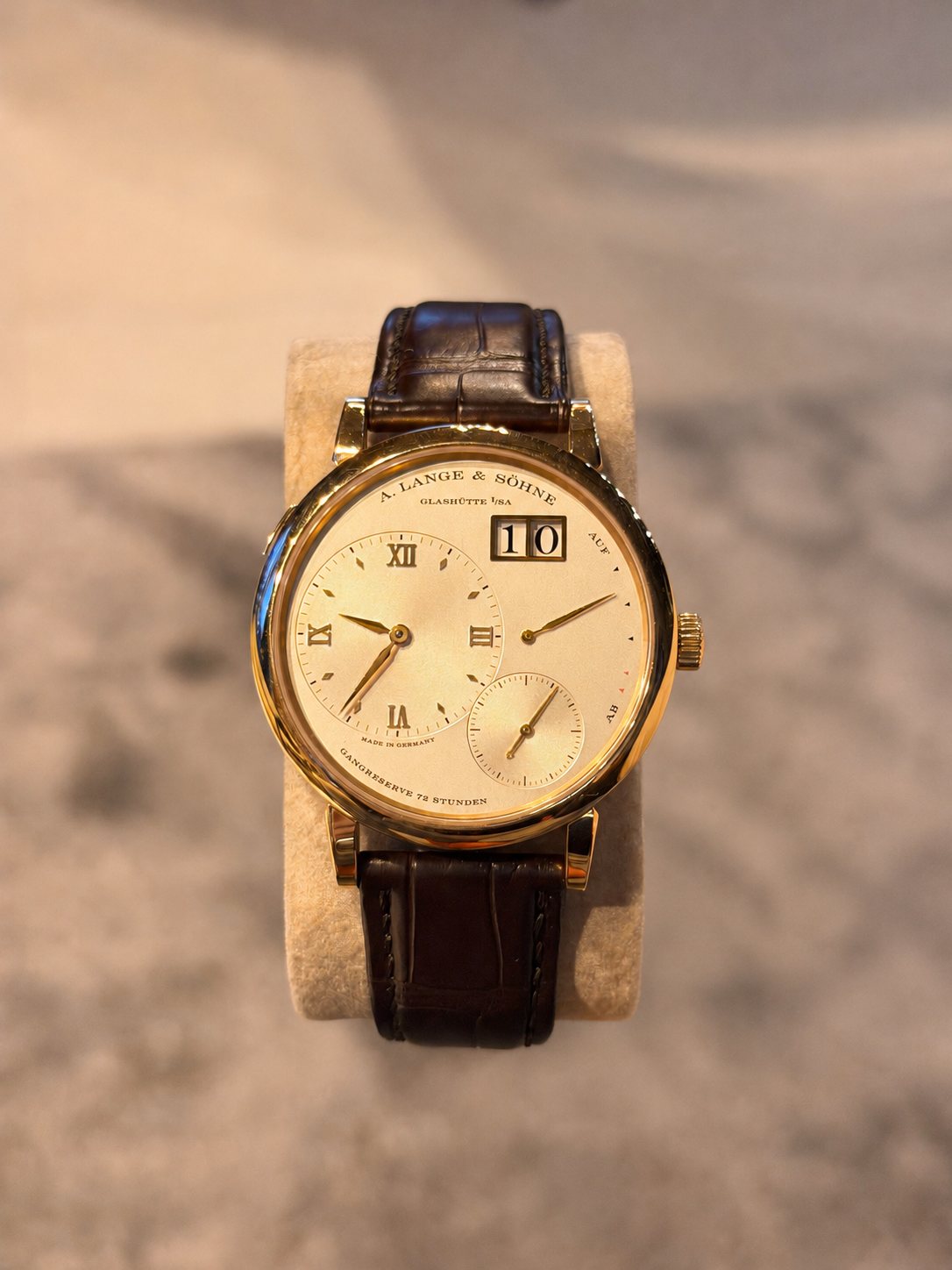 A. Lange & Söhne Lange 1 in yellow gold, resting on a watch cushion